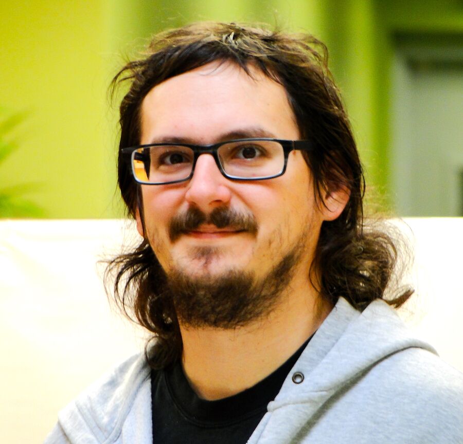 Jonathan Enzinna smiling, in glasses and a gray hoodie